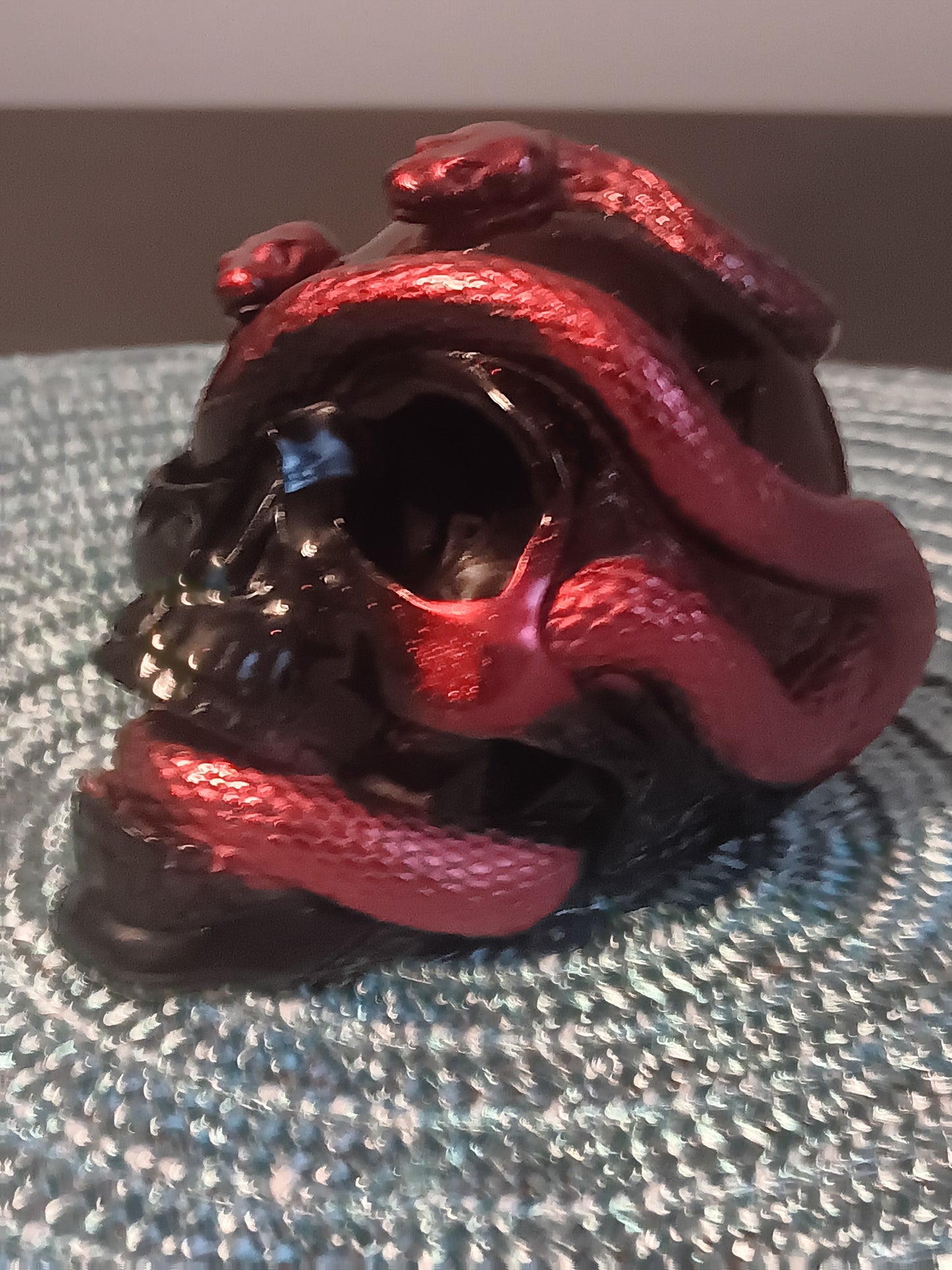 Small Black Skull intertwined with Red Snakes
